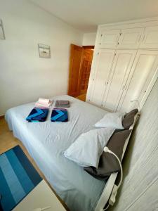 a bedroom with a bed with two blueippers on it at Casa Las Torres 209 in Costa de Antigua