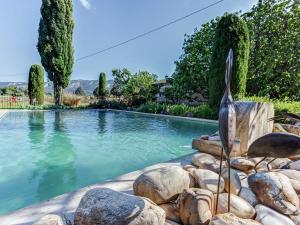 - une piscine avec une statue d'un oiseau près des rochers dans l'établissement Charming Cottage in Opp de amidst Vineyards, à Maubec