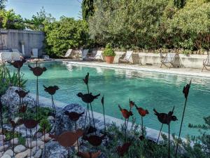 - une piscine avec quelques fleurs en face dans l'établissement Charming Cottage in Opp de amidst Vineyards, à Maubec