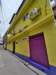ein farbenfrohes Gebäude mit einer lila Garage in der Unterkunft Ribini house in Seoul