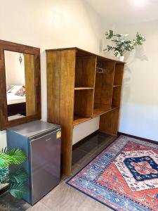 a room with a refrigerator and wooden shelves at Jungle Vibes in Thongsala