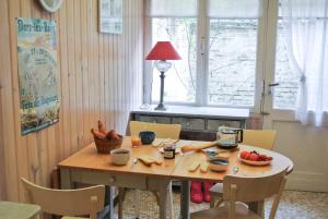 a dining room table with fruit and vegetables on it at Villa Señorita dans le quartier historique de Mers-les-Bains, 100m de la plage in Mers-les-Bains