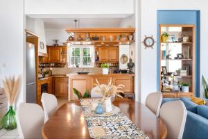 a kitchen and dining room with a wooden table and chairs at Villa peristeri in Alinda