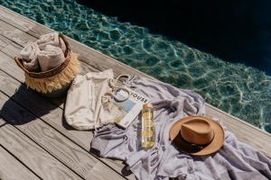 ein Haufen Kleidung und ein Hut neben dem Wasser in der Unterkunft Pure Sea Boutique Lodge in Gansbaai