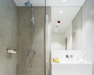 een douche met een glazen deur in de badkamer bij Marriott Executive Apartments Brussels in Brussel