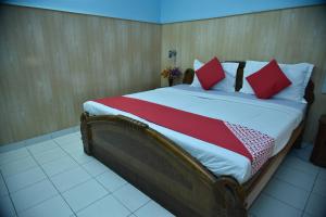 a large bed with red pillows in a room at Collection O City Heart in Hisār