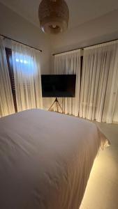 um quarto com uma grande cama branca e janelas em Matteo Villa Limassol Cyprus em Limassol