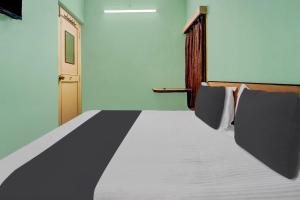 a bed in a room with a door and a bed sidx sidx sidx at OYO Rainbow Stays in Tiruchirappalli