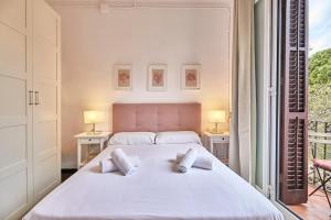 バルセロナにあるBBarcelona Sagrada Familia Garden Apartmentのベッドルーム(白い大型ベッド、ランプ2つ付)