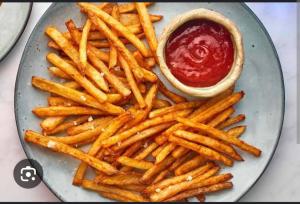 a plate of french fries and a sandwich with ketchup at Queen Palace guest house in Srinagar