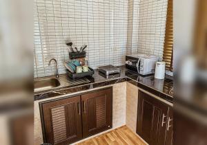 a kitchen with a sink and a microwave on a counter at Hm House Patong in Patong Beach