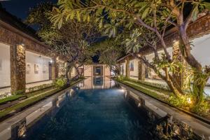 an indoor pool with trees in a building at Villa Samudra Raya in Seminyak