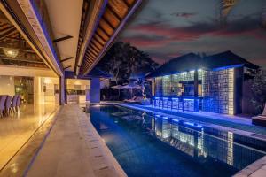 an infinity pool in a house at night at Villa Samudra Raya in Seminyak
