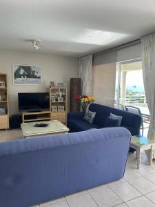 a living room with a blue couch and a table at 22 Lands End in Ballito
