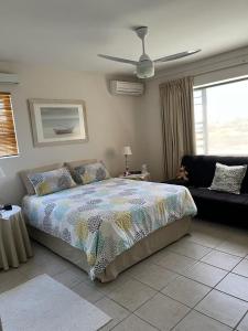a bedroom with a bed and a couch at 22 Lands End in Ballito