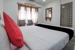 a bedroom with a large white bed with red pillows at Collection O Hotel Jaisas Paradise in Agastīswaram