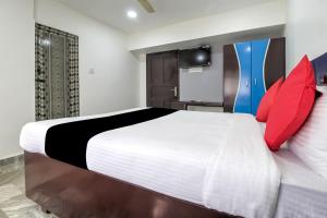 a bedroom with a large bed with red pillows at Collection O Hotel Jaisas Paradise in Agastīswaram