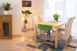 a dining room table with white chairs and a green table at Ferienwohnung in ruhigem Viertel in Rhodt unter Rietburg