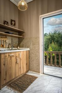 a kitchen with a sink and a sliding glass door at Koklas Studios in Lithakia