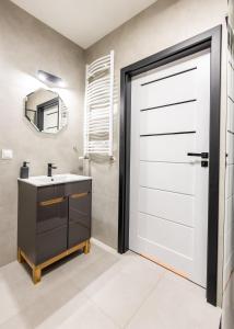 uma casa de banho com uma porta branca e um lavatório em Apartament 32 em Gąski