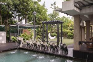 eine Gruppe von Elefanten steht neben einem Schwimmbecken in der Unterkunft 25,000sq.ft Grand Luxe Villa PJ 13BR 42Pax By Verano in Petaling Jaya + 212 Fotos