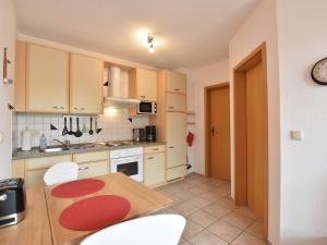 a kitchen with a wooden table and white cabinets at Seaside Apartment in Insel Poel with Sauna in Timmendorf