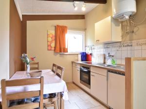 a small kitchen with a table and a sink at Quaint Bungalow near Insel Poel with Garden in Insel Poel
