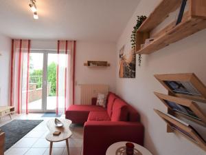 ein Wohnzimmer mit einem roten Sofa und einem Fenster in der Unterkunft Seaside Apartment in Insel Poel with Sauna in Timmendorf
