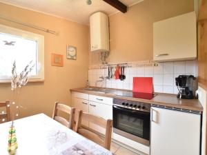 a kitchen with a stove and a dining room table at Quaint Bungalow near Insel Poel with Garden in Insel Poel