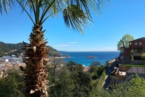 a palm tree with a view of the ocean at 4 bedrooms property with private pool terrace and wifi at Tossa de Mar in Tossa de Mar