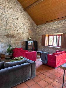 uma sala de estar com dois sofás e uma parede de pedra em 3 bedrooms house with private pool terrace and wifi at Porto de Mos em Porto de Mós