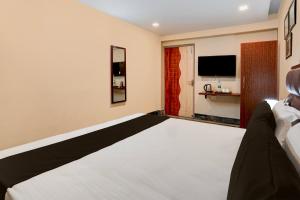 A bed or beds in a room at OYO Flagship Hotel Awadh Court