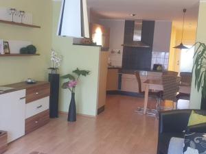 a kitchen and a living room with a vase with flowers at Cosy apartment in Eibenstock in Eibenstock