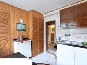 キュールングスボルンにあるCharming Apartment in K hlungsborn with Parkingの木製の壁と白い家電製品が備わるキッチン