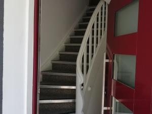 uma escada numa casa com uma parede vermelha em Apartment in Oppenau near Black Forest National Park em Oppenau