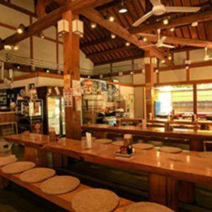 Watarase Onsen Hotel Yamayuri في هونغو: مطعم بطاولات خشبية وكراسي في الغرفة