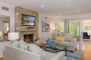 uma sala de estar com um sofá e uma lareira de pedra em Quite Spacious, Hot Tub Near Montecito, EV Charger em Santa Bárbara
