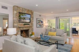 a living room with a couch and a stone fireplace at Quite Spacious, Hot Tub Near Montecito, EV Charger in Santa Barbara