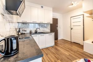 a kitchen with white cabinets and a counter top at Apartament 33 in Gąski