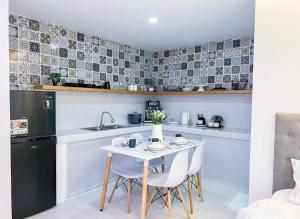 a small kitchen with a white table and chairs at Moonlight House Tagaytay in Tagaytay