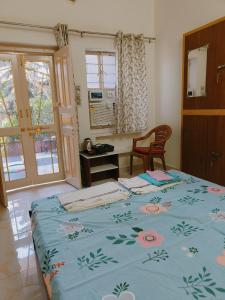 Un dormitorio con una cama con una manta azul con flores en Homestay Urmil Basant, en Jaipur