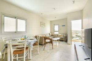 een keuken en een woonkamer met een tafel en stoelen bij Skyline 1BR Apartment with City and Sea View by Sea N' Rent in Herzelia 