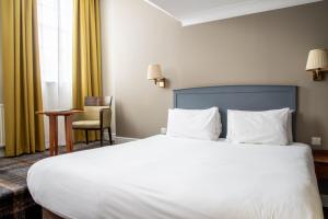 a hotel room with a large bed and a chair at Arnos Manor Hotel in Bristol