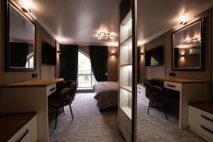 a bedroom with a bed and a desk and a mirror at Sobor Family Resort in Stavcheny