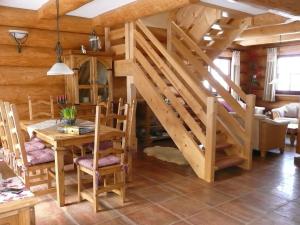 a dining room with a staircase in a log cabin at Cozy wooden house in Waltershausen near the forest in Emsetal