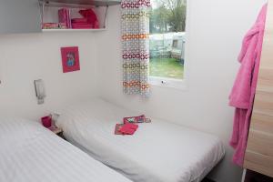 2 camas individuales en una habitación con ventana en Happy Lodge, en Alphen