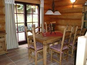 a dining room with a wooden table and chairs at Cozy wooden house in Waltershausen near the forest in Emsetal