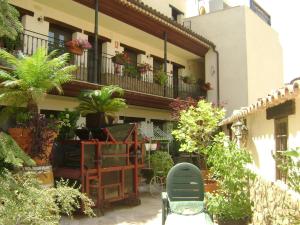 a courtyard with chairs and potted plants on a building at Apartamentos Rurales La Muralla II in Cañete