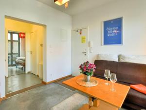 ヴィスマールにあるModern Apartment in Wismar with Private Terraceのリビングルーム(ソファ、ワイングラス付きのテーブル付)