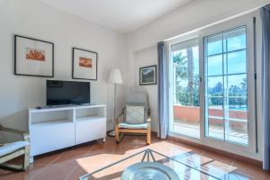 a living room with a tv and a large window at Hoyo I by Ĥ - Isla Canela Golf GHHI16IA3P78 in Isla Canela